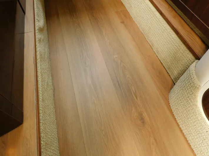 Luna Sea Yacht Photos Pics Wooden flooring and carpet detail inside a 2015 Sea Ray 310 Sundancer boat.