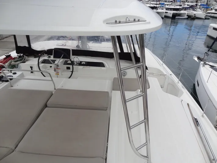 Shamwari Yacht Photos Pics 2020 Lagoon 46 catamaran deck with seating, steering wheel, and marina view.
