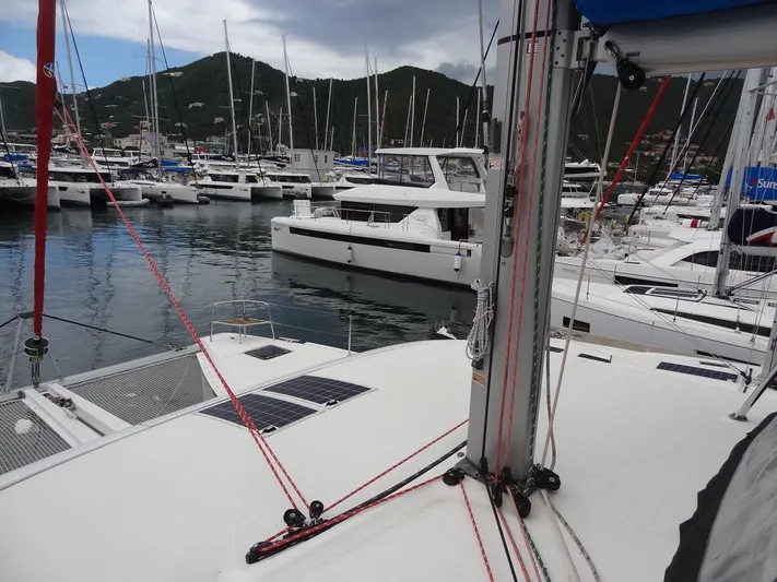 Shamwari Yacht Photos Pics Catamaran Lagoon 46, 2020 model, docked in a marina with surrounding boats.