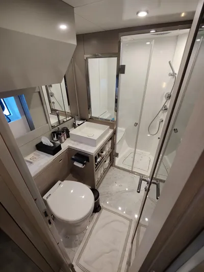  Yacht Photos Pics Luxurious bathroom in 2023 Sirena 68 yacht with modern fixtures and glass shower.