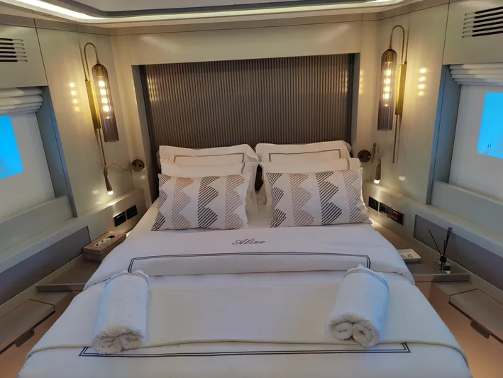  Yacht Photos Pics Luxurious bedroom interior of 2023 Sirena 68 yacht with elegant bedding and ambient lighting.