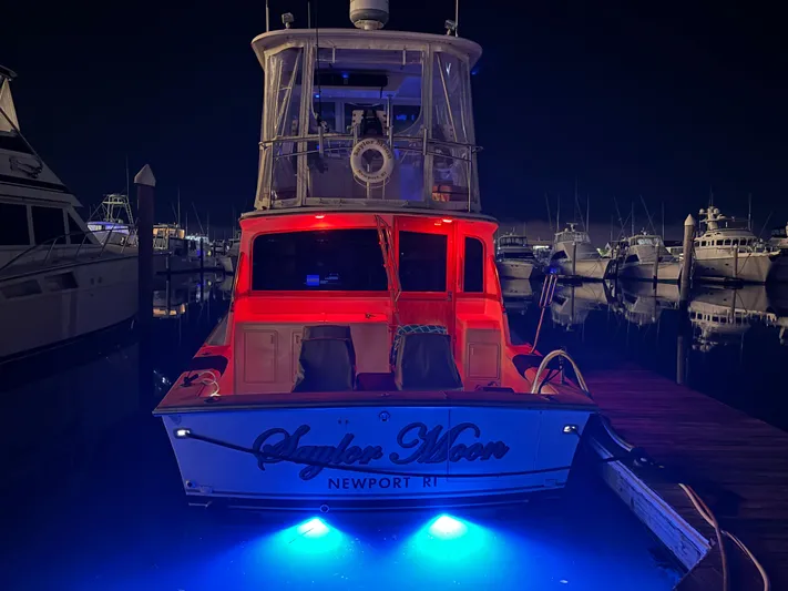 Saylor Moon Yacht Photos Pics 1990 Ocean Yachts 48 Super Sport docked at night with blue underwater lights.