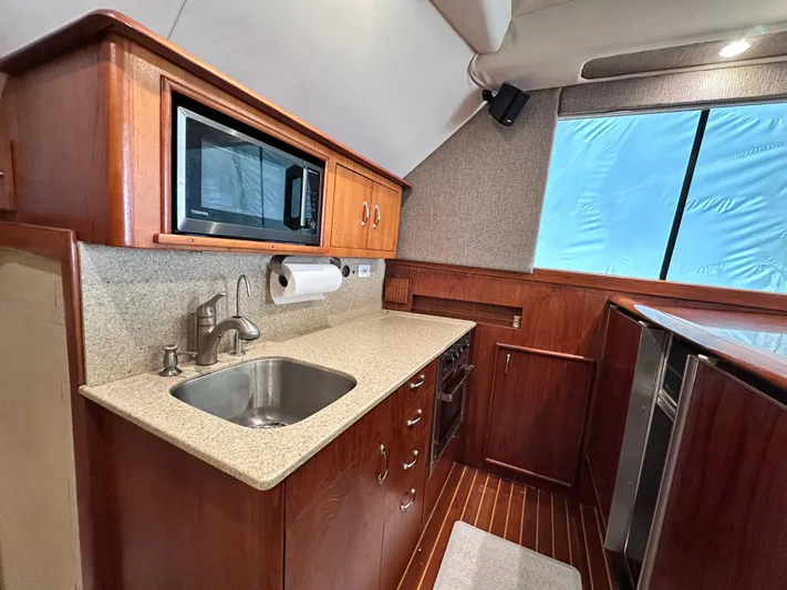 Saylor Moon Yacht Photos Pics 1990 Ocean Yachts 48 Super Sport yacht kitchen with wood cabinetry and modern appliances.