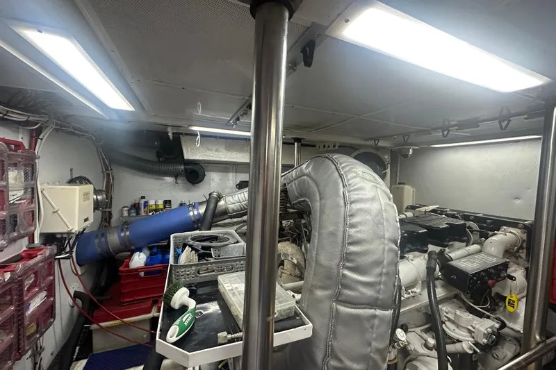 Patrona Yacht Photos Pics Engine room of a 2000 Mikelson 61 Sportfisher, featuring mechanical components and storage.