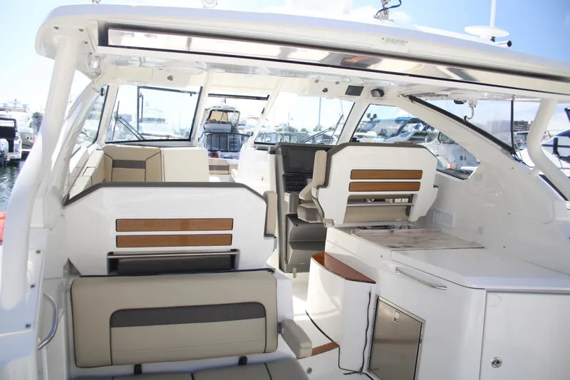 Flawless Seas Yacht Photos Pics 2019 Pursuit DC 365 Dual Console boat interior with seating and helm, docked at marina.