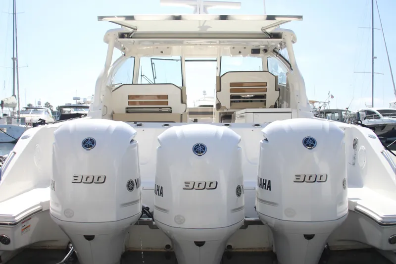 Flawless Seas Yacht Photos Pics 2019 Pursuit DC 365 Dual Console boat with triple Yamaha 300 engines at a marina.