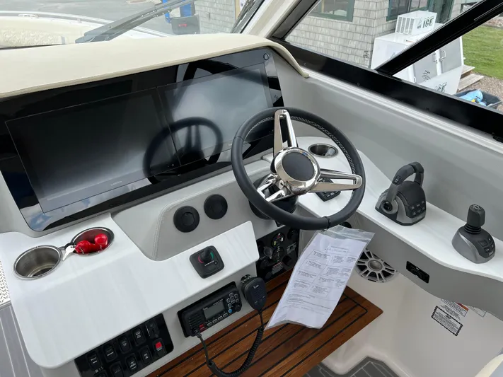  Yacht Photos Pics 2022 Regal LS36 boat helm with steering wheel, controls, and navigation screen.