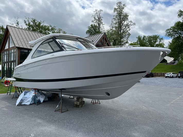  Yacht Photos Pics 2022 Regal LS36 boat on display outdoors, surrounded by trees and buildings.