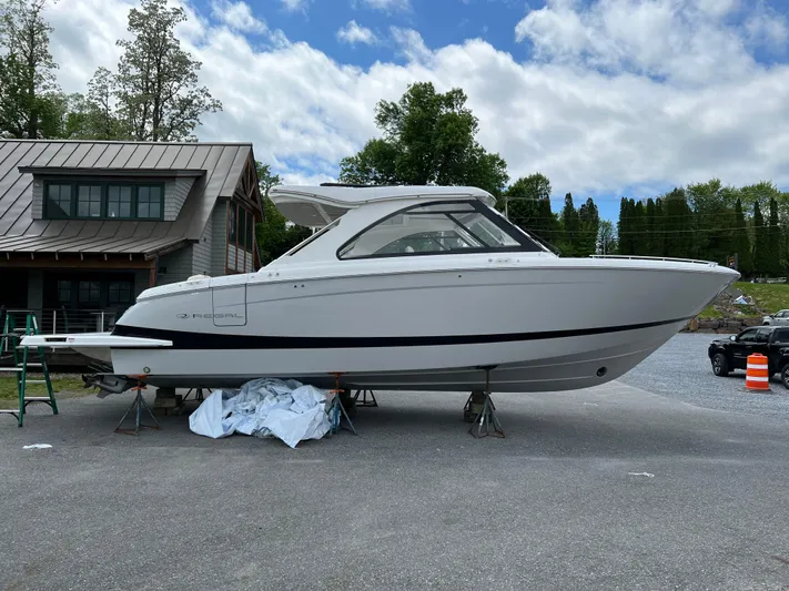  Yacht Photos Pics 2022 Regal LS36 boat on display outdoors near a modern building.