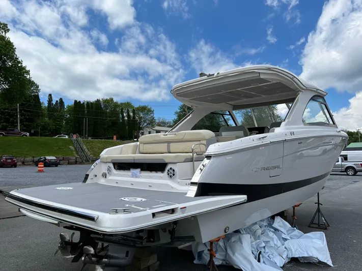  Yacht Photos Pics 2022 Regal LS36 boat with spacious deck, parked outdoors under a blue sky.