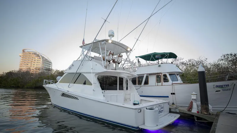 Todo Shine Yacht Photos Pics 2007 Viking 45 Convertible yacht docked at marina with modern building in background.