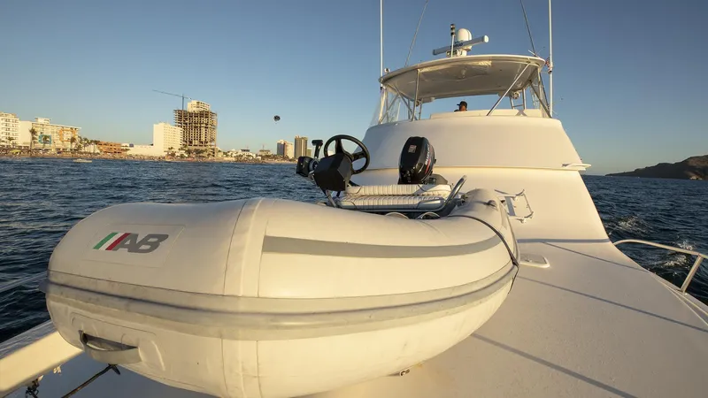 Todo Shine Yacht Photos Pics 2007 Viking 45 Convertible yacht with inflatable boat on deck, cruising near coastal city skyline.