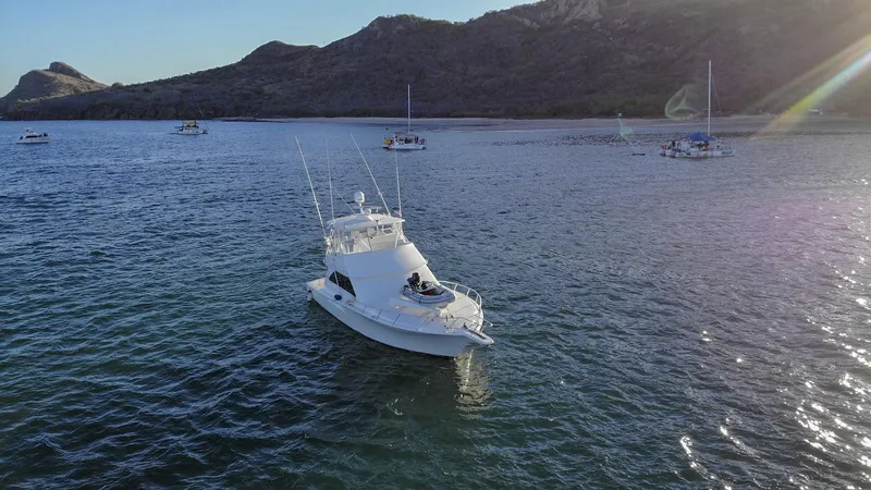 Todo Shine Yacht Photos Pics 2007 Viking 45 Convertible yacht on calm waters with scenic mountain backdrop.