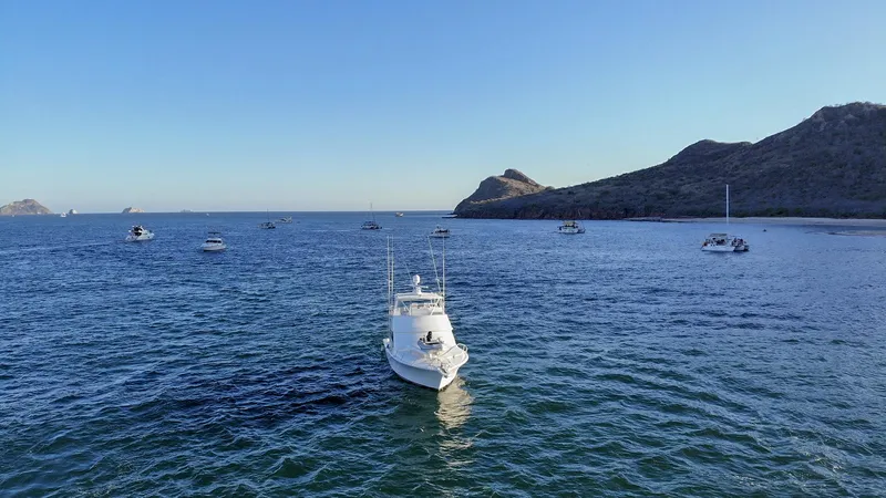 Todo Shine Yacht Photos Pics A 2007 Viking 45 Convertible yacht on a serene ocean with distant hills.