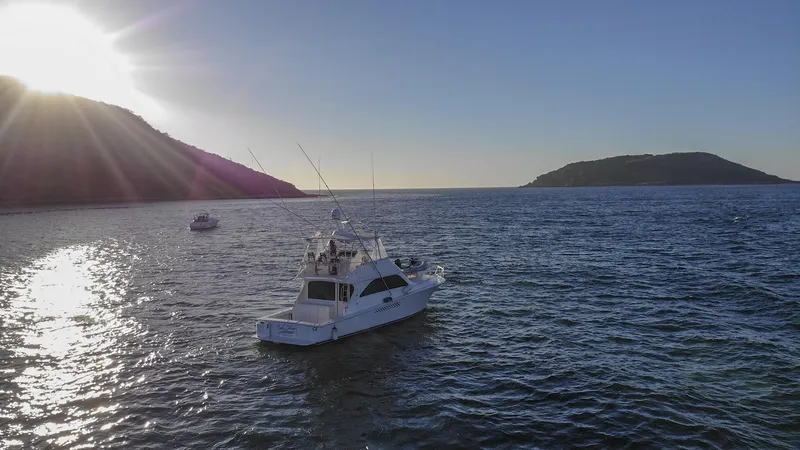 Todo Shine Yacht Photos Pics 2007 Viking 45 Convertible yacht on serene ocean at sunset, with distant islands.