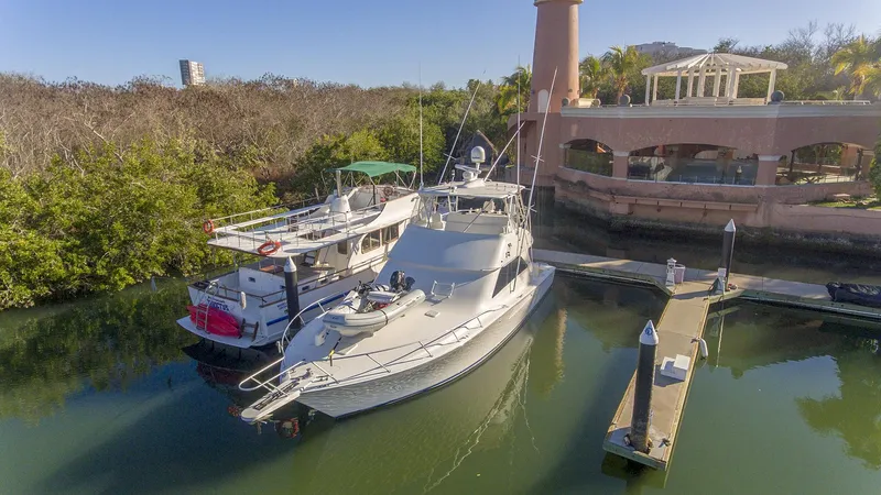 Todo Shine Yacht Photos Pics 2007 Viking 45 Convertible yacht docked near a waterfront building.