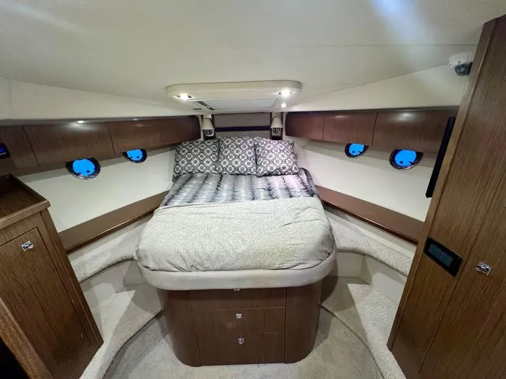  Yacht Photos Pics Luxurious cabin interior of 2014 Cruisers Yachts 540 SC with cozy bed and elegant wood finish.