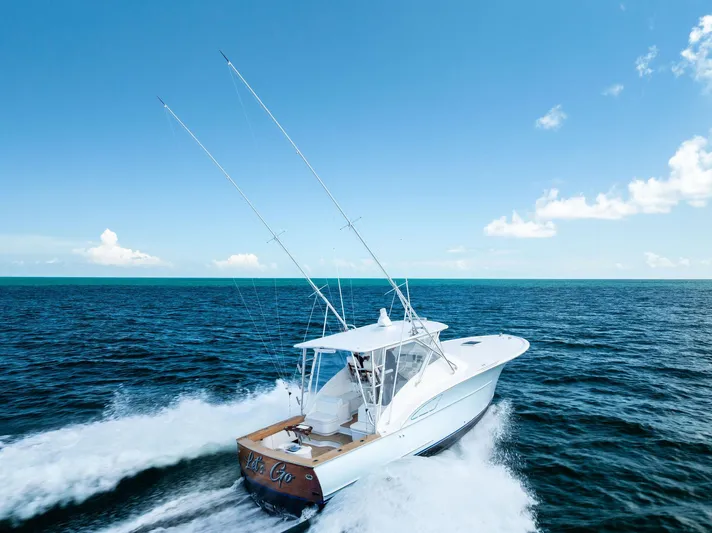 Let's Go Yacht Photos Pics 2018 Custom Carolina 35 Express yacht cruising on open ocean under clear blue sky.