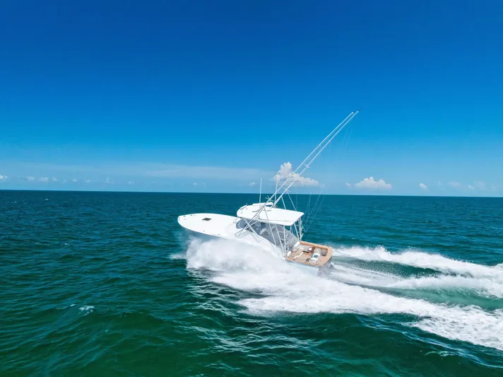 Let's Go Yacht Photos Pics 2018 Custom Carolina 35 Express cruising on open ocean under clear blue sky.