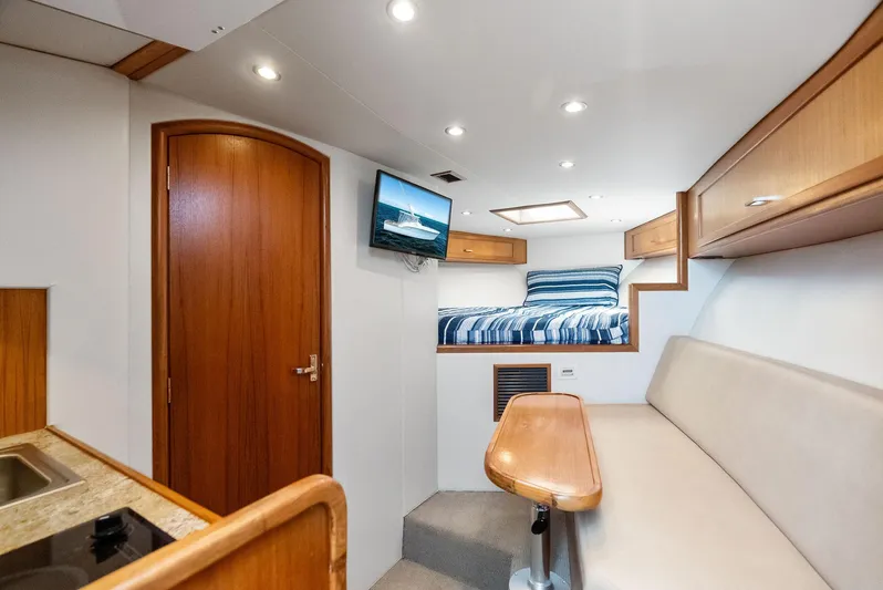 Let's Go Yacht Photos Pics 2018 Custom Carolina 35 Express cabin interior with bed, seating, and TV.