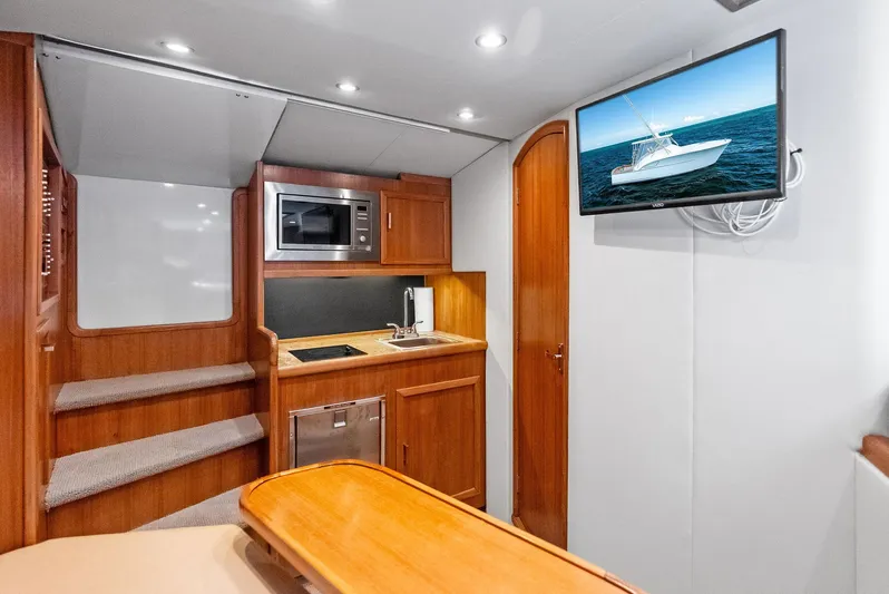 Let's Go Yacht Photos Pics Interior of 2018 Custom Carolina 35 Express yacht with kitchenette and TV display.