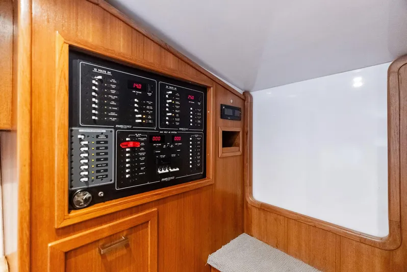 Let's Go Yacht Photos Pics Electrical panel inside 2018 Custom Carolina 35 Express boat, featuring wooden cabinetry.
