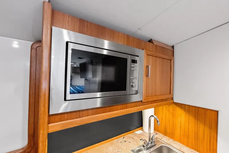 Let's Go Yacht Photos Pics Modern kitchen area in 2018 Custom Carolina 35 Express boat with microwave and sink.