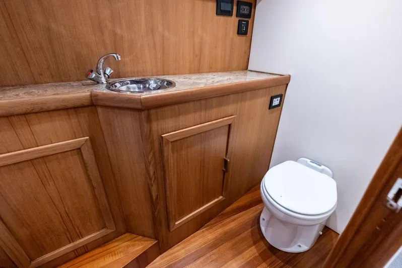 Let's Go Yacht Photos Pics 2018 Custom Carolina 35 Express boat bathroom with wooden cabinetry and compact toilet.