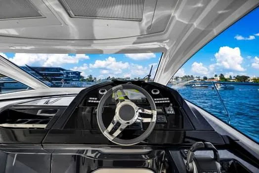 2023 Beneteau Gt45 Yacht Photos Pics 2023 Beneteau Gran Turismo 45 yacht cockpit with steering wheel, overlooking serene blue waters.