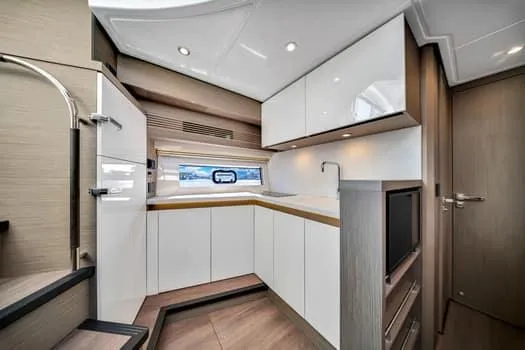2023 Beneteau Gt45 Yacht Photos Pics Modern kitchen interior of 2023 Beneteau Gran Turismo 45 yacht, featuring sleek cabinetry and appliances.