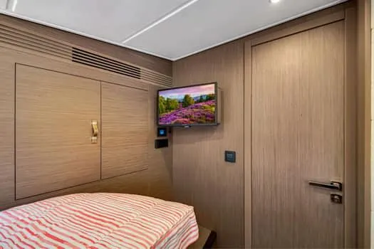 2023 Beneteau Gt45 Yacht Photos Pics 2023 Beneteau Gran Turismo 45 cabin interior with TV and striped bedding.