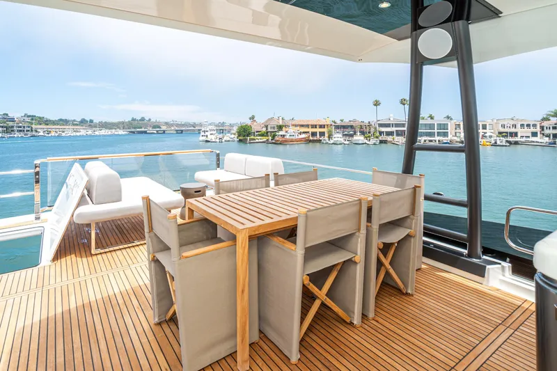  Yacht Photos Pics Luxurious 2024 Prestige X60 yacht deck with elegant seating and scenic waterfront view.
