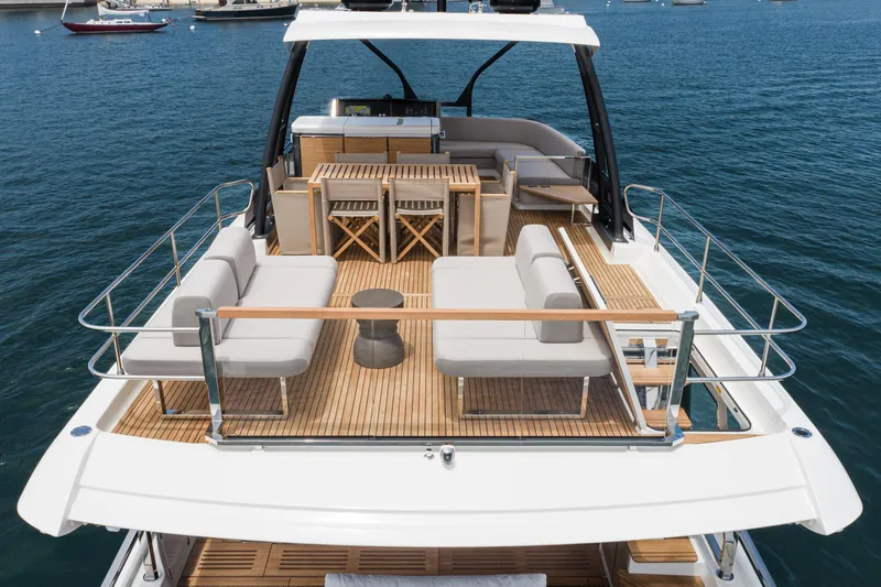  Yacht Photos Pics Luxurious 2024 Prestige X60 yacht with elegant deck seating and dining area on the water.