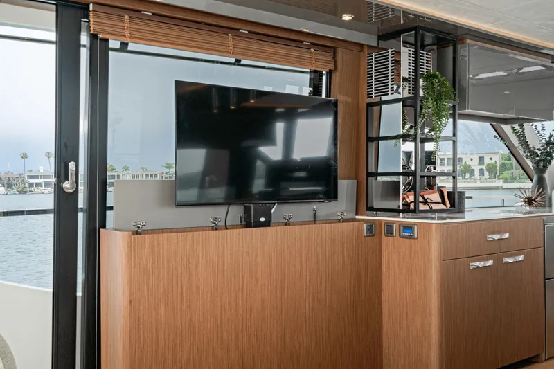  Yacht Photos Pics 2024 Prestige X60 yacht interior with modern TV setup and elegant wood cabinetry.