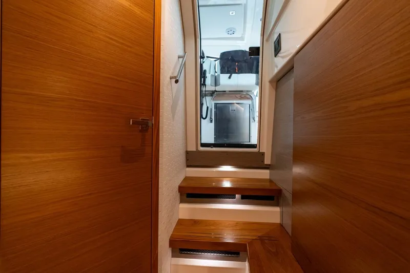  Yacht Photos Pics Interior stairs of 2024 Tiara Sport 34 LS yacht, featuring sleek wooden design.