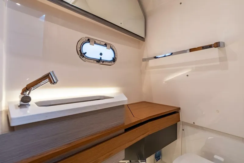  Yacht Photos Pics 2024 Tiara Sport 34 LS yacht bathroom with modern sink and porthole window.