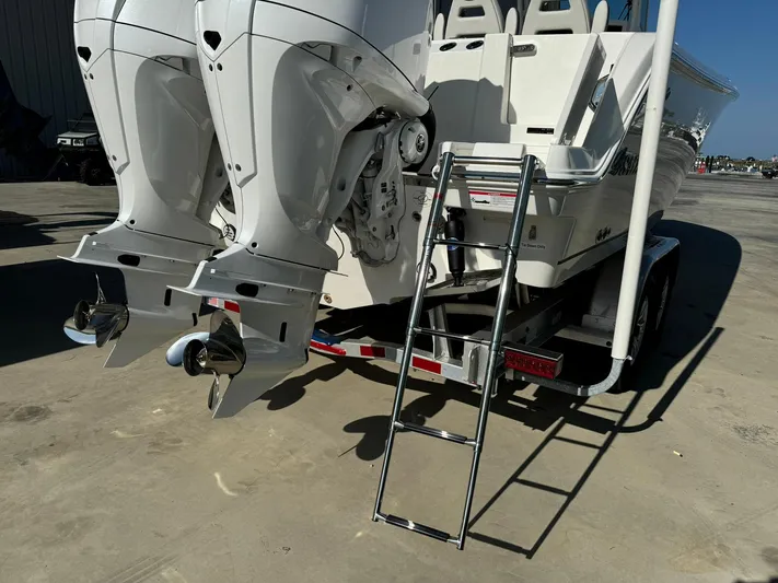  Yacht Photos Pics 2025 Sailfish 272 CC boat with dual outboard motors and ladder on trailer.