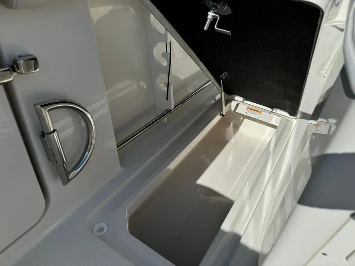  Yacht Photos Pics 2025 Sailfish 272 CC boat storage compartment with open hatch and sleek design.