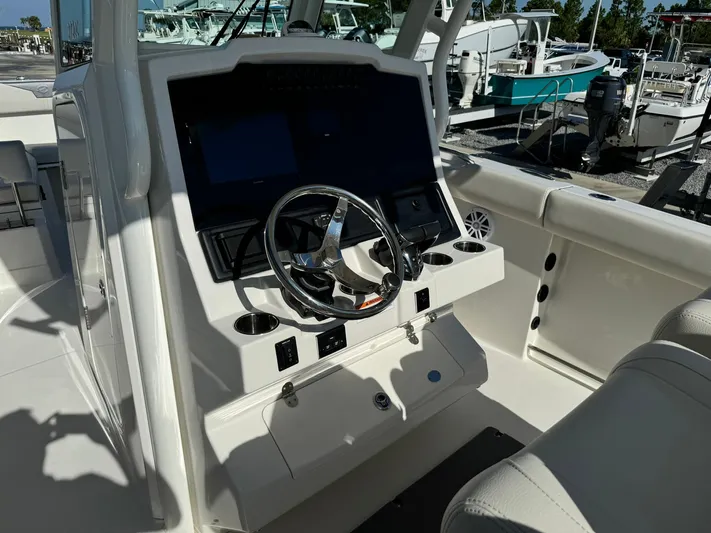  Yacht Photos Pics 2025 Sailfish 272 CC boat cockpit with steering wheel and control panel.
