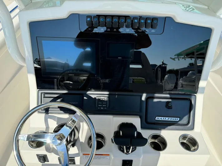  Yacht Photos Pics 2025 Sailfish 272 CC boat dashboard with steering wheel and electronic controls.