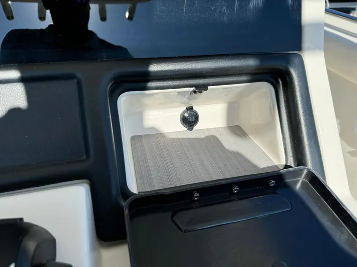  Yacht Photos Pics 2025 Sailfish 272 CC boat storage compartment with black trim and latch.