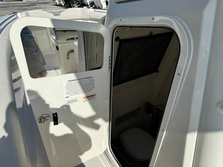  Yacht Photos Pics 2025 Sailfish 272 CC boat interior with open door revealing compact bathroom.