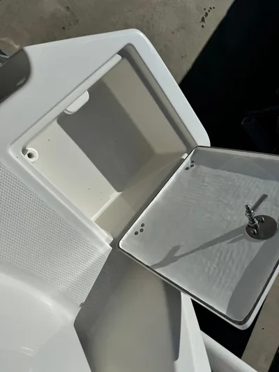  Yacht Photos Pics 2025 Sailfish 272 CC storage compartment with open lid and key.