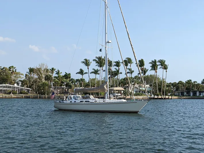 Colleen Yacht Photos Pics 1984 Cambria 44/46 sailboat anchored near palm trees on a sunny day.