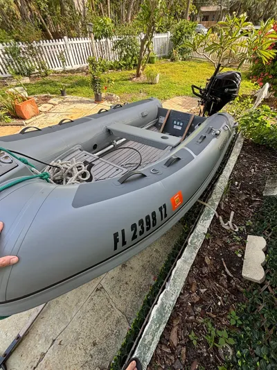 Colleen Yacht Photos Pics Gray inflatable boat with outboard motor, Cambria 44/46 model, 1984, in a garden setting.