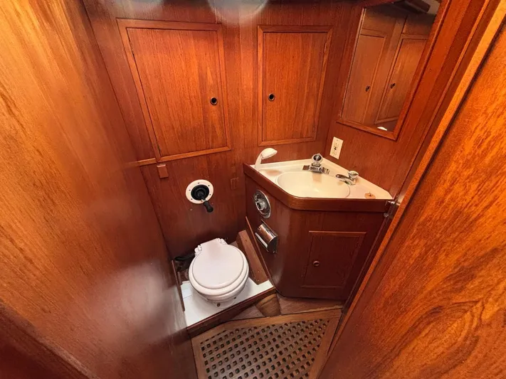 Colleen Yacht Photos Pics 1984 Cambria 44/46 yacht bathroom with wooden interior, sink, and toilet.