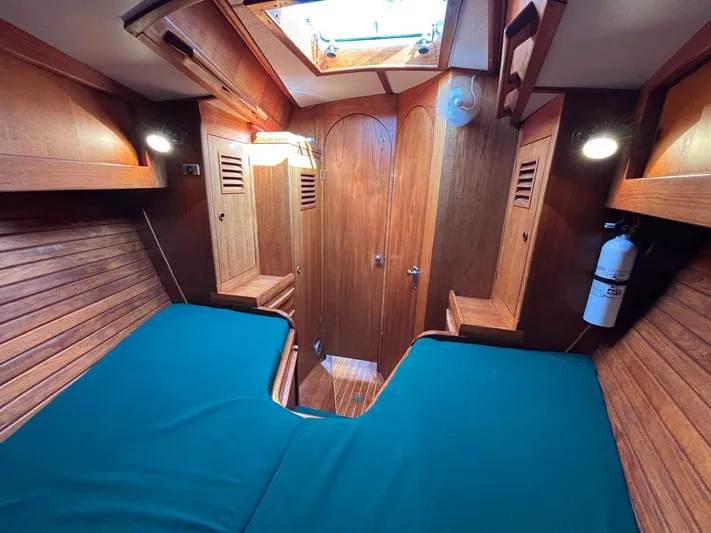 Colleen Yacht Photos Pics Wooden interior of 1984 Cambria 44/46 yacht cabin with teal bedding and skylight.
