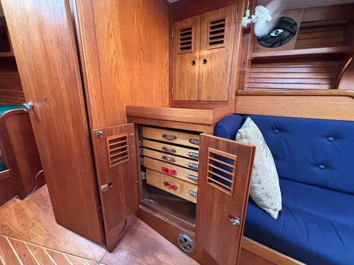 Colleen Yacht Photos Pics Wooden interior of 1984 Cambria 44/46 yacht with storage drawers and blue cushioned seating.