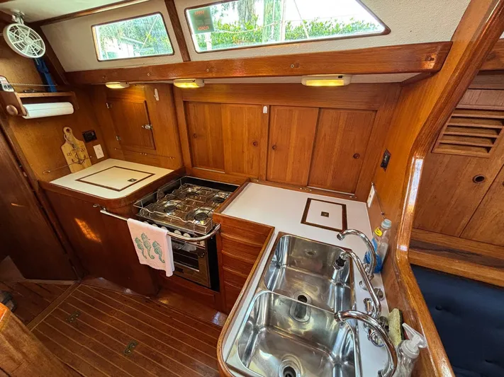 Colleen Yacht Photos Pics 1984 Cambria 44/46 yacht kitchen with wood cabinetry, stove, and double sink.