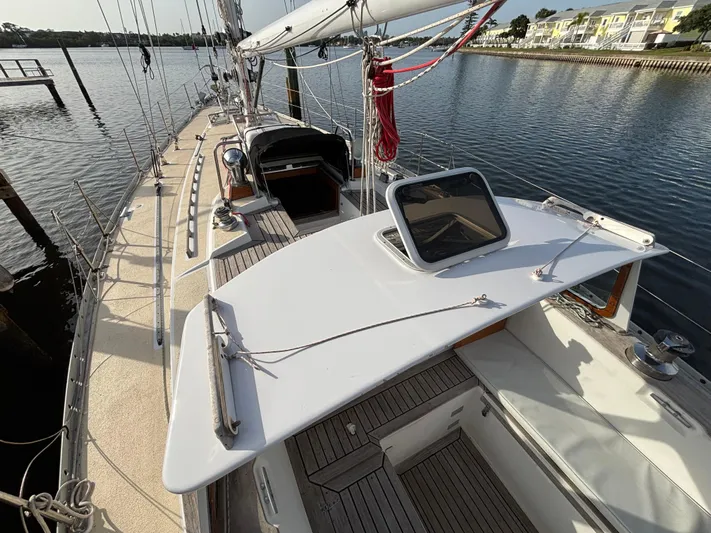 Colleen Yacht Photos Pics 1984 Cambria 44/46 sailboat deck with open hatch, docked by calm waters.